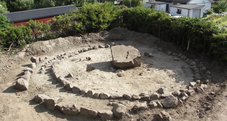 En större sten, cirka 2 meter i diameter, omgärdas av två cirklar med mindre stenar.